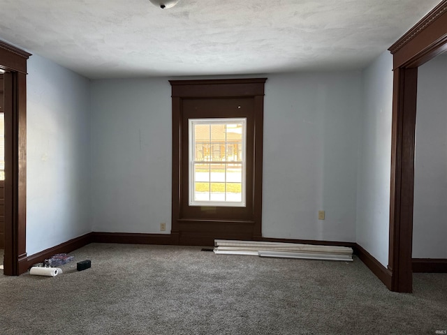 carpeted empty room with a textured ceiling