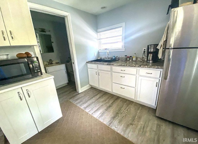 kitchen with stainless steel appliances, white cabinetry, and sink