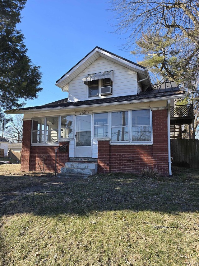 view of front of home featuring cooling unit and a front yard