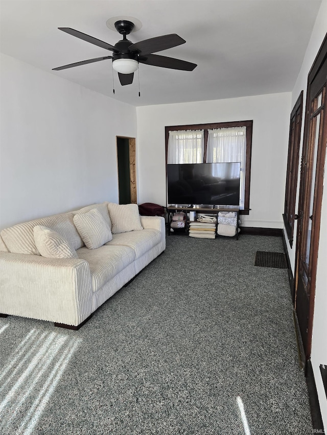 living room featuring ceiling fan and dark colored carpet