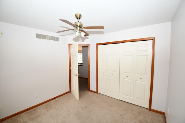 unfurnished bedroom featuring light carpet, ceiling fan, and a closet