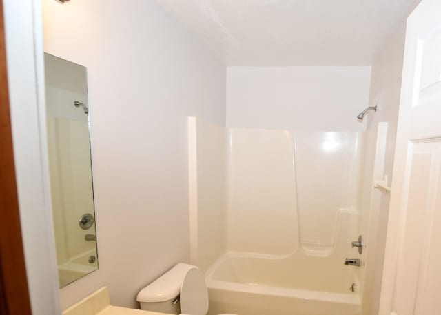 bathroom featuring shower / tub combination and toilet