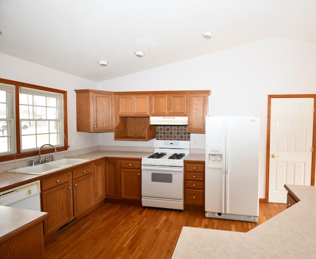 kitchen featuring vaulted ceiling, white appliances, light hardwood / wood-style floors, and sink