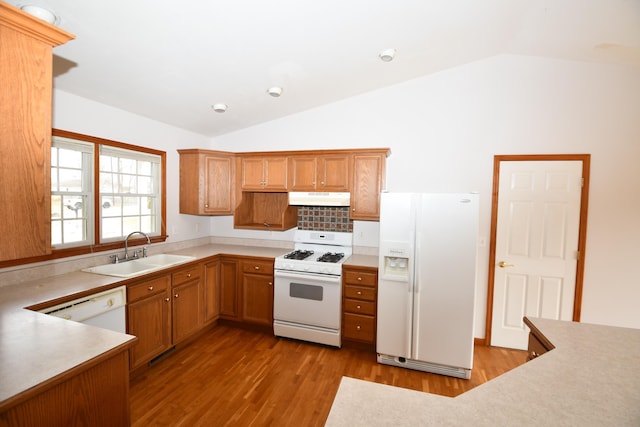 kitchen featuring vaulted ceiling, white appliances, light hardwood / wood-style floors, and sink