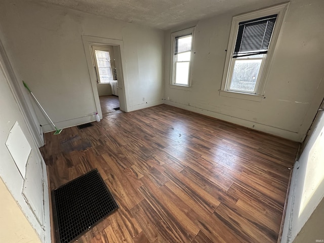 unfurnished room with hardwood / wood-style floors and a textured ceiling