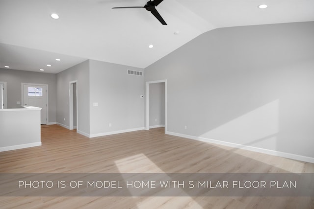 spare room with ceiling fan, vaulted ceiling, and light wood-type flooring