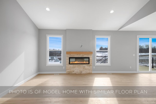 unfurnished living room with vaulted ceiling and light wood-type flooring