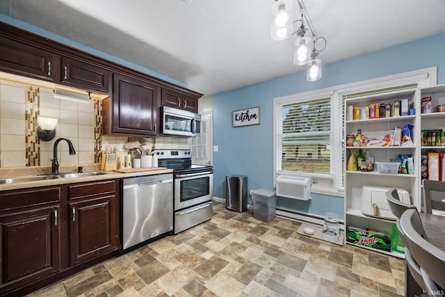 kitchen featuring sink, decorative light fixtures, dark brown cabinets, stainless steel appliances, and decorative backsplash