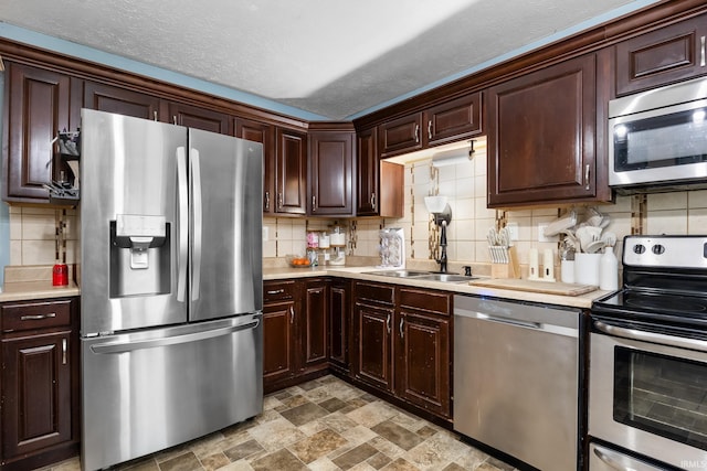 kitchen featuring stainless steel appliances, dark brown cabinets, backsplash, and a textured ceiling