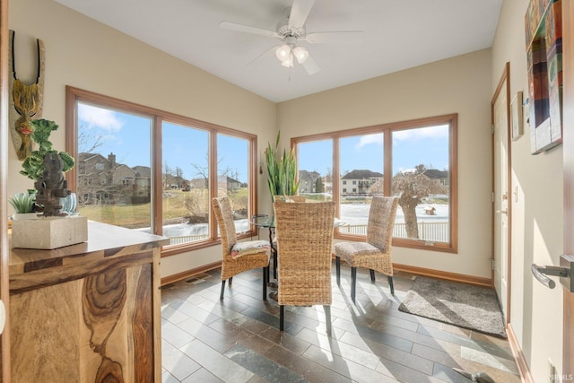 sunroom / solarium featuring ceiling fan