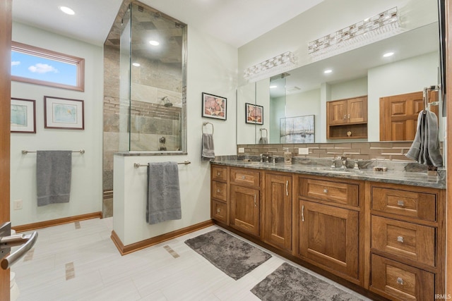 bathroom with vanity, a tile shower, and decorative backsplash