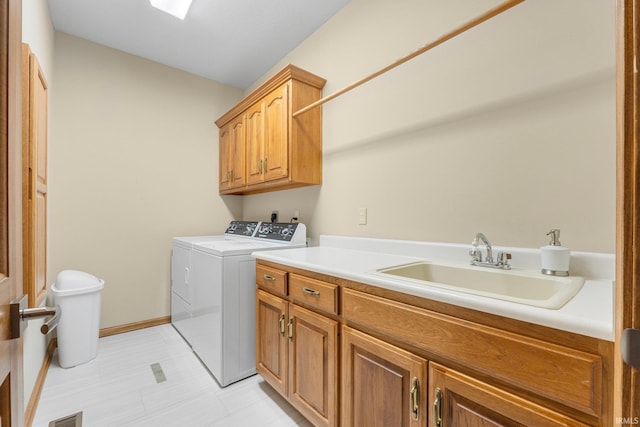 washroom featuring separate washer and dryer, sink, and cabinets