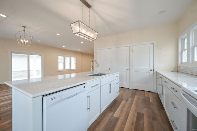 kitchen with white cabinetry, sink, hanging light fixtures, a notable chandelier, and white appliances