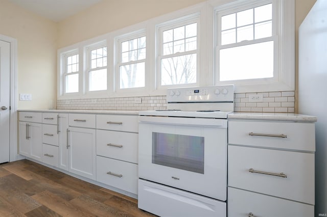 kitchen with tasteful backsplash, white cabinets, dark wood-type flooring, and electric range