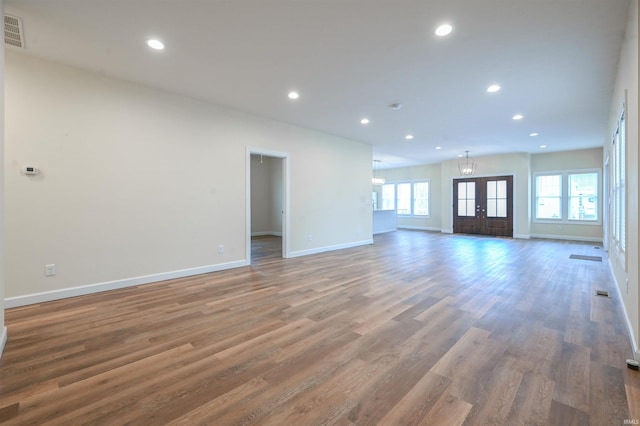 unfurnished living room featuring dark wood-type flooring and french doors