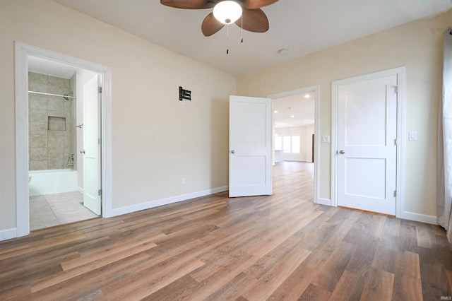 unfurnished bedroom with hardwood / wood-style floors, ensuite bath, and ceiling fan