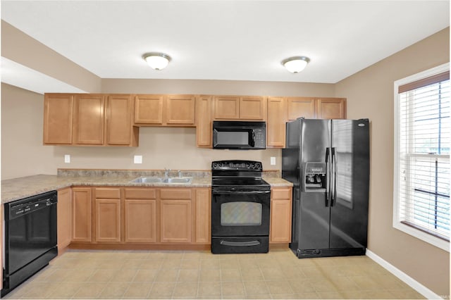 kitchen with a wealth of natural light, sink, light brown cabinets, and black appliances