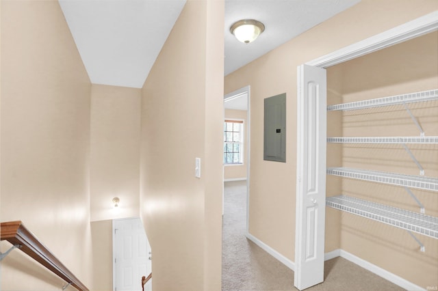 hallway with light carpet and electric panel