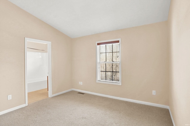 spare room with lofted ceiling and carpet floors