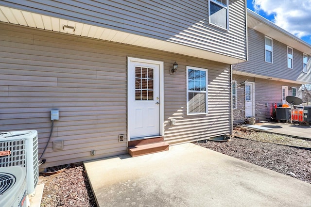 property entrance featuring cooling unit and a patio area