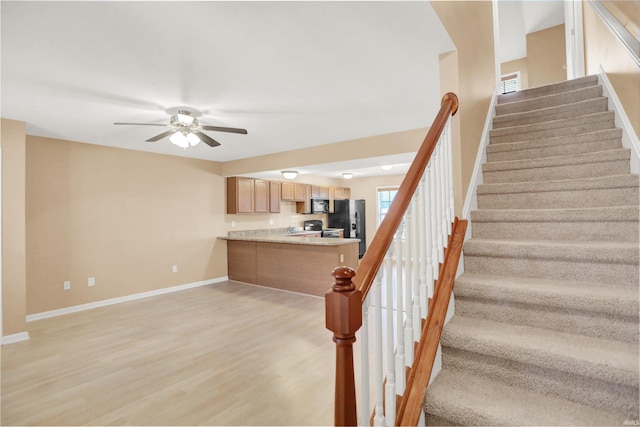 staircase with hardwood / wood-style flooring and ceiling fan