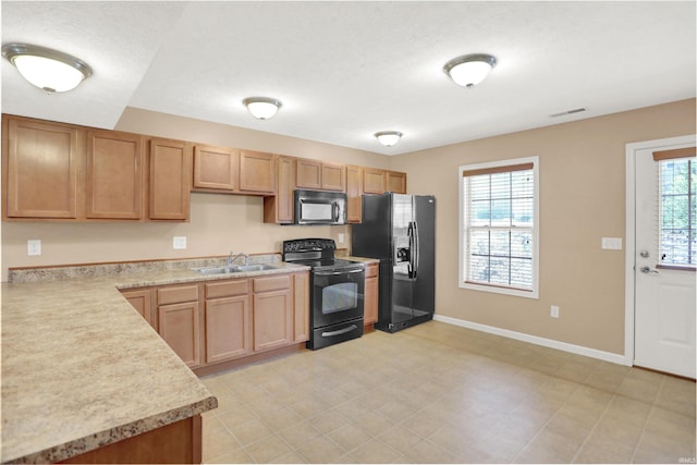 kitchen with sink, black appliances, and a textured ceiling