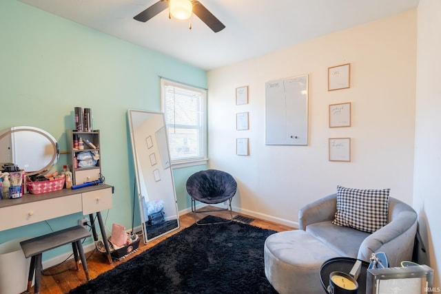 living area featuring wood-type flooring and ceiling fan