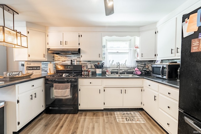 kitchen with tasteful backsplash, white cabinetry, sink, and black appliances