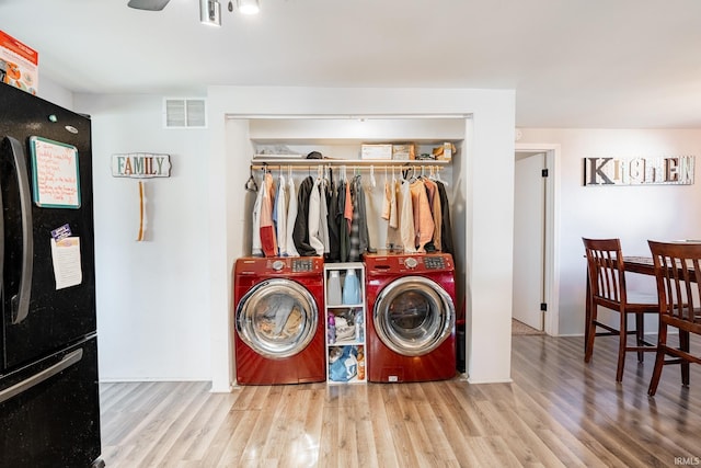 laundry area featuring ceiling fan, washer and dryer, and light hardwood / wood-style flooring