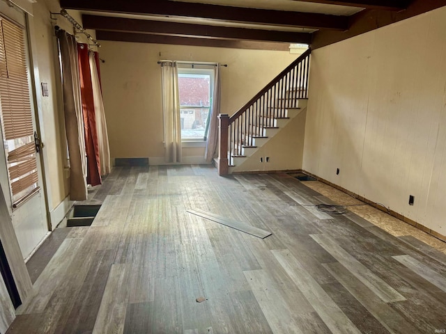 unfurnished living room with hardwood / wood-style flooring and beam ceiling