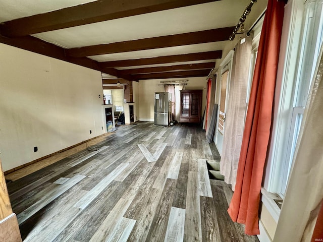 unfurnished living room with dark wood-type flooring and beamed ceiling