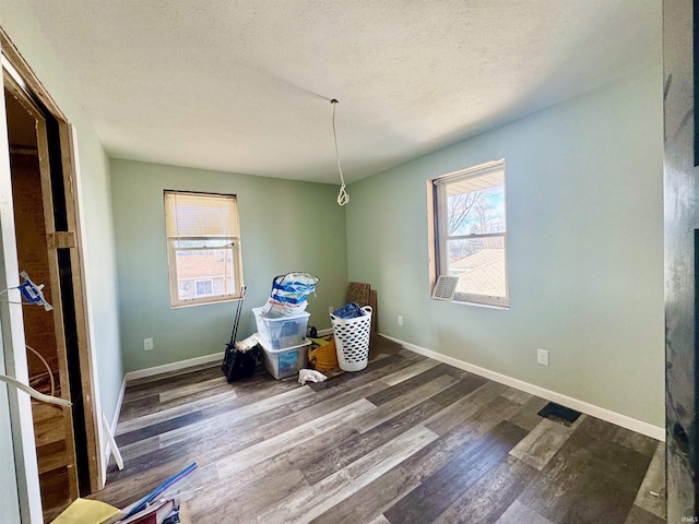 unfurnished room with dark hardwood / wood-style floors, a wealth of natural light, and a textured ceiling