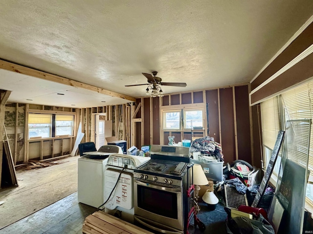 kitchen with a textured ceiling, stainless steel range with gas cooktop, ceiling fan, and plenty of natural light