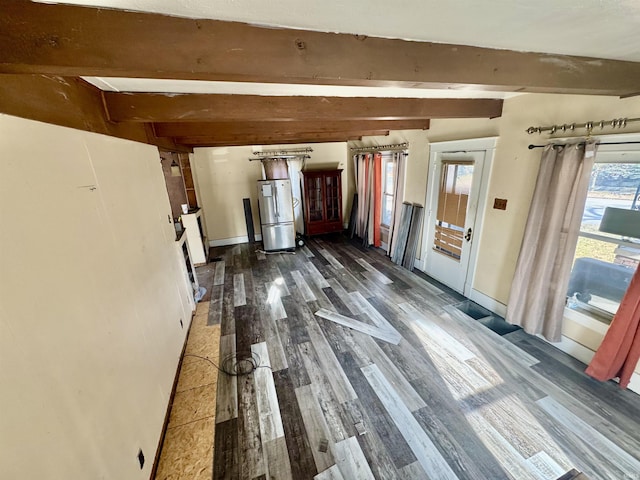 interior space featuring dark hardwood / wood-style flooring, beam ceiling, and a wealth of natural light