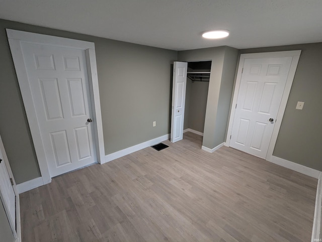 unfurnished bedroom with a closet and light hardwood / wood-style flooring