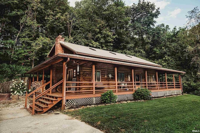 log cabin with a front yard and covered porch