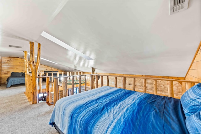 carpeted bedroom with wooden walls and vaulted ceiling