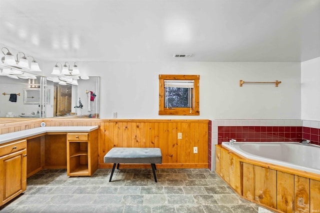 bathroom featuring vanity and a washtub