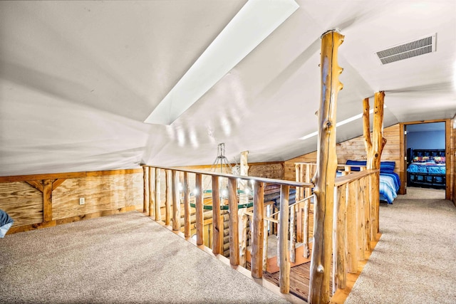 bonus room featuring vaulted ceiling, carpet floors, and wood walls