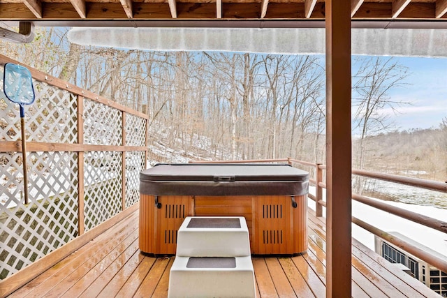 snow covered deck with a hot tub