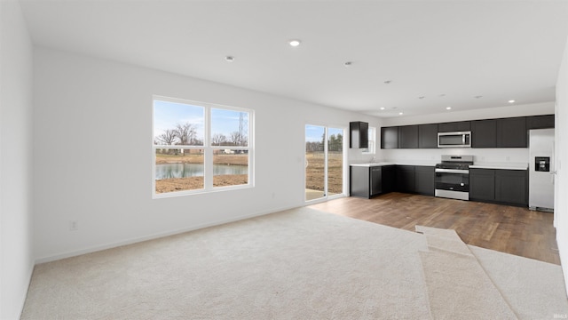 kitchen with light carpet, light countertops, recessed lighting, and stainless steel appliances