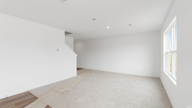 carpeted spare room with stairs