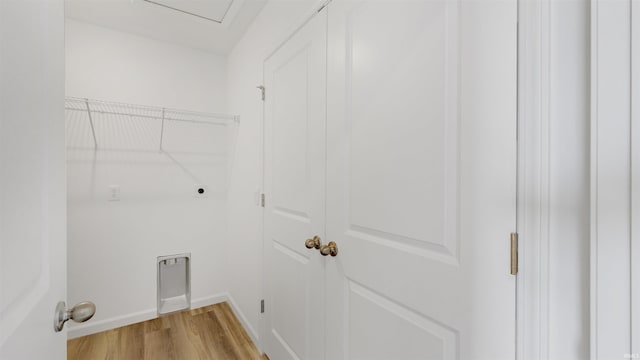 laundry room featuring light wood finished floors, baseboards, hookup for an electric dryer, and laundry area