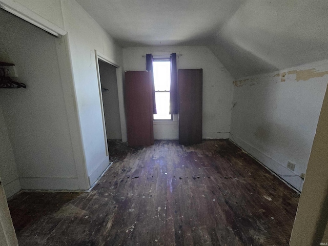 additional living space featuring lofted ceiling and dark hardwood / wood-style floors