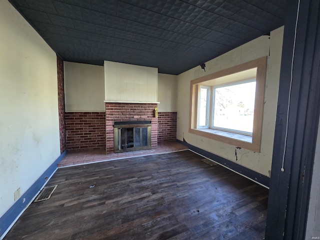 unfurnished living room with a fireplace and dark hardwood / wood-style floors