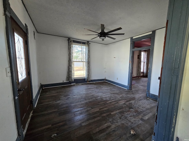 empty room with dark wood-type flooring, ceiling fan, and a textured ceiling