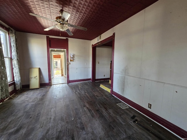 empty room with dark wood-type flooring and ceiling fan