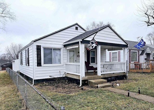 bungalow with a front yard and covered porch