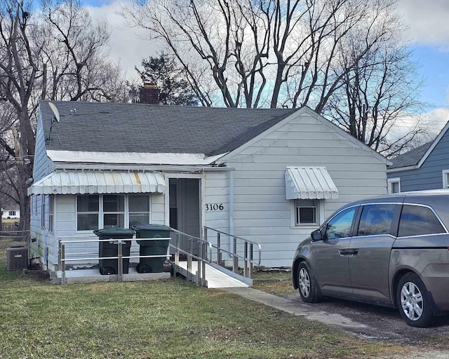 view of front facade with a front lawn and central air condition unit