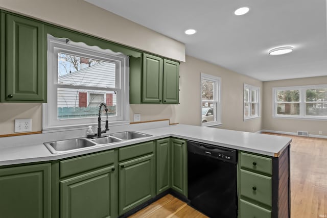 kitchen featuring sink, plenty of natural light, black dishwasher, green cabinetry, and kitchen peninsula